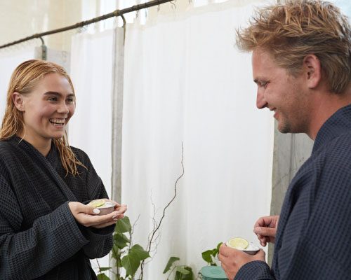 Kvinde og mand dufter til urter og salt på deres luksus spa-rejse hos Sofiebadet på Christianshavn